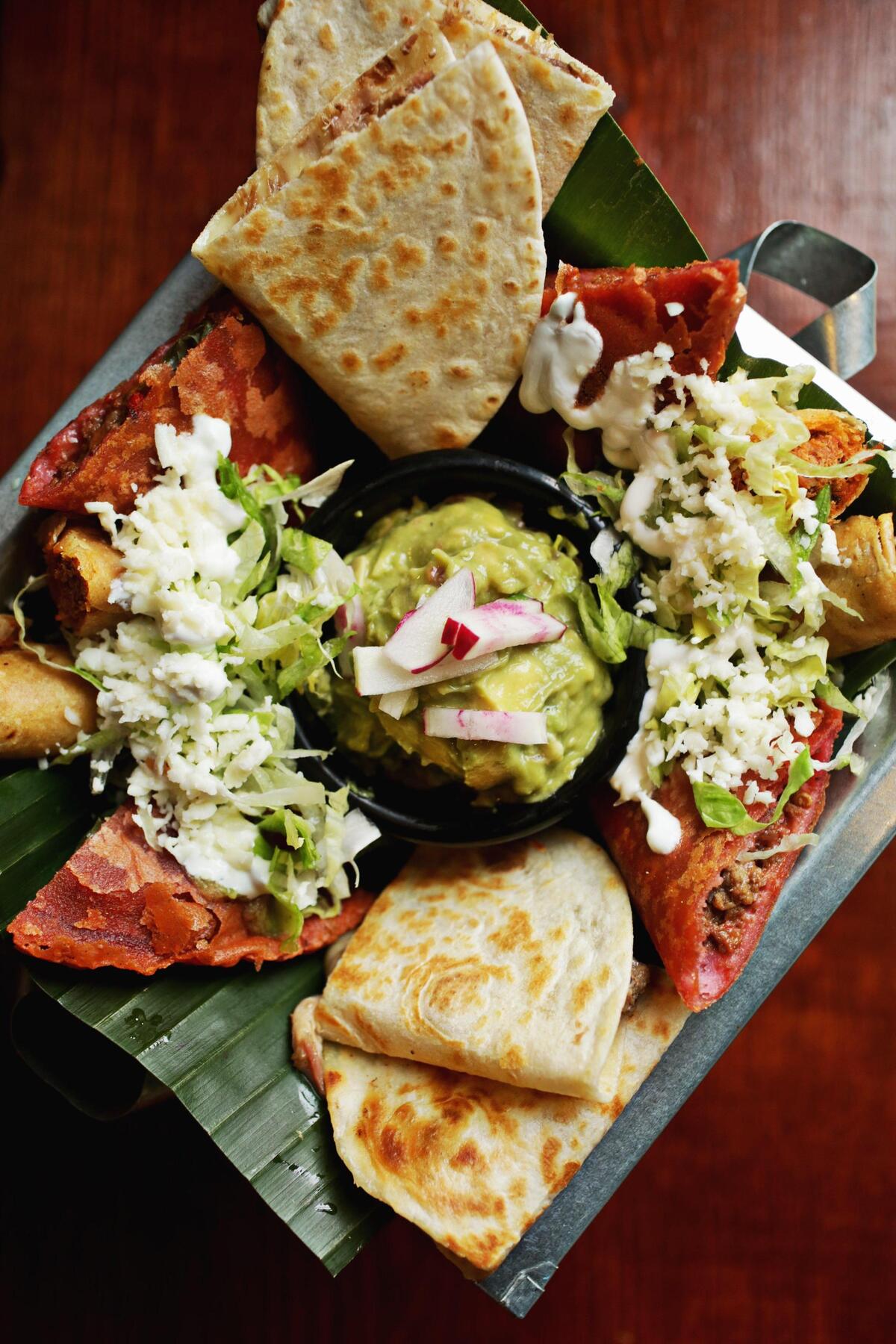 Frida’s Patio in Cary serves a snack chingon as an appetizer combo that features a generous sampling of chicken taquitos, beef empanadas, a carnitas quesadilla and chunky guacamole.