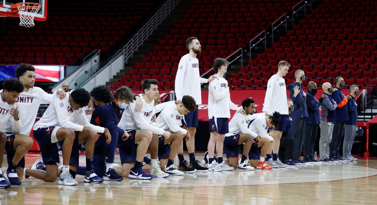 Some Virginia players kneel during the national anthem before N.C. State’s game against Virginia at PNC Arena in Raleigh, N.C., Wednesday, February 3, 2021.