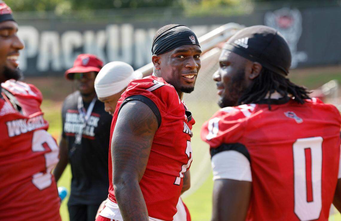 N.C. State running back Jordan Waters (7) talks with Jordan Poole (3) and Kendrick Raphael (0) during the Wolfpack’s first practice in Raleigh, N.C., Wednesday, July 31, 2024.
