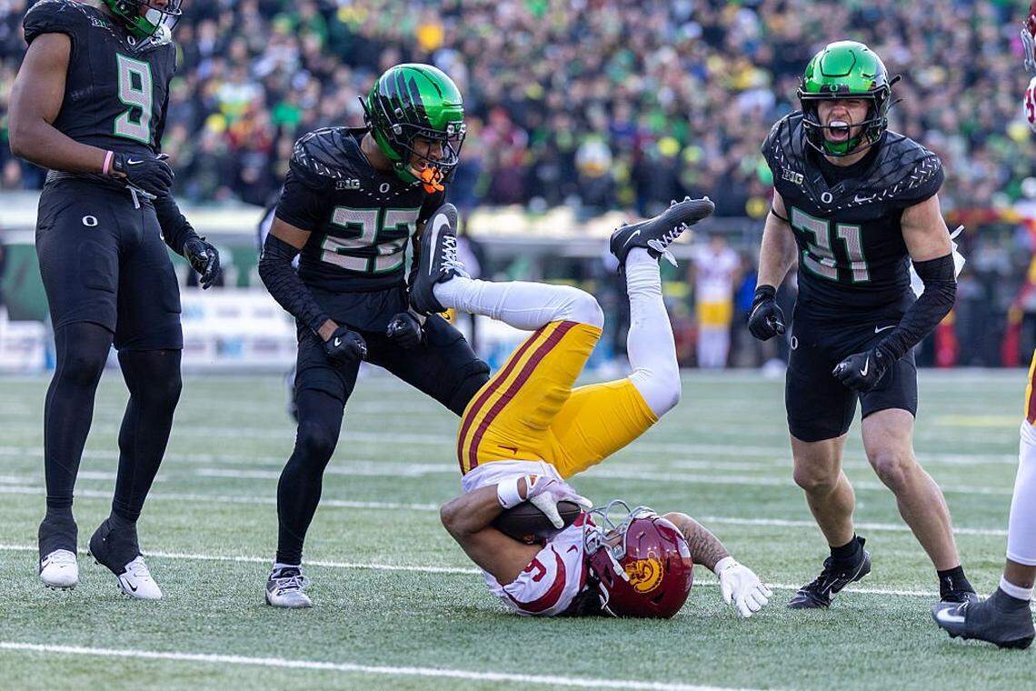 EUGENE, OREGON - NOVEMBER 22: Makai Lemon #6 of the Southern California Trojans is tackled by Dillon Thieneman #31 of the Oregon Ducks and Jadon Canady #22 of the Oregon Ducksin the first half against the Oregon Ducks at Autzen Stadium on November 22, 2025 in Eugene, Oregon. (Photo by Tom Hauck/Getty Images)