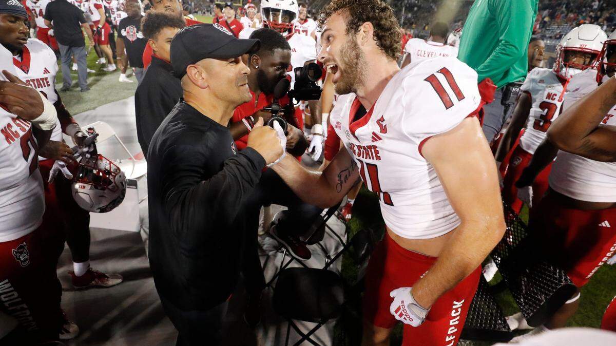 N.C. State defensive coordinator Tony Gibson congratulates Payton Wilson (11) after he intercepted the ball during the Wolfpack’s 24-14 victory over UConn at Rentschler Field in East Hartford, Conn. Thursday, August 31, 2023.