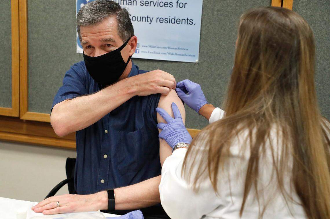 Michelle Winings, R.N., prepares to give Gov. Roy Cooper his flu shot at the Wake County Health Department in Raleigh, N.C., Friday, Sept. 25, 2020.