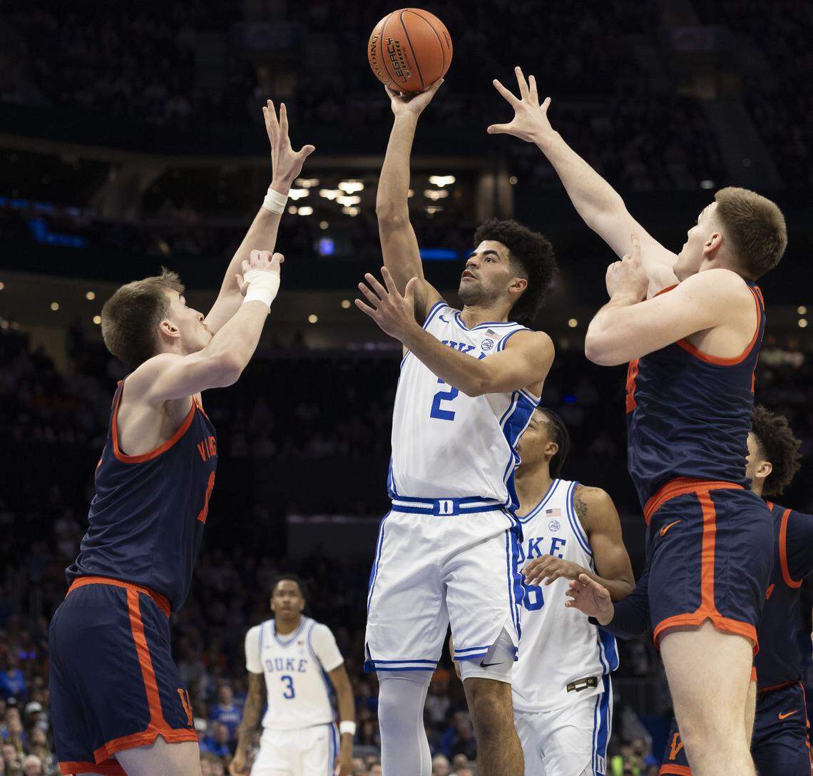 Duke guard Cayden Boozer (2) puts up a shot against Virginia center Johann Grunloh (17) and forward Thijs De Ridder (28) in the first half on Saturday, March 14, 2026, during the ACC Tournament Championship at Spectrum Center in Charlotte, N.C.