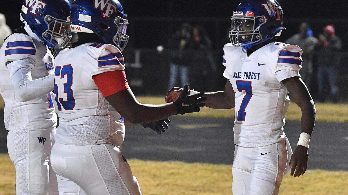 Wake Forest quarterback Kavon Simmons (7) celebrates with Marcus Smith (53) after running in the touchdown against Rolesville. The Rolesville Rams and the Wake Forest Cougars met in the second round of the NCHSAA 4A Football Playoffs in Rolesville, N.C. on November 10, 2023.