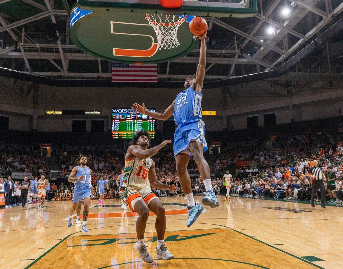 North Carolina’s Harrison Ingram (55) breaks to the basket for a dunk ahead of Miami’s Norchad Omier (15) in the first half on Saturday, February 10, 2024 at the Watsco Center in Coral Gables, Florida.