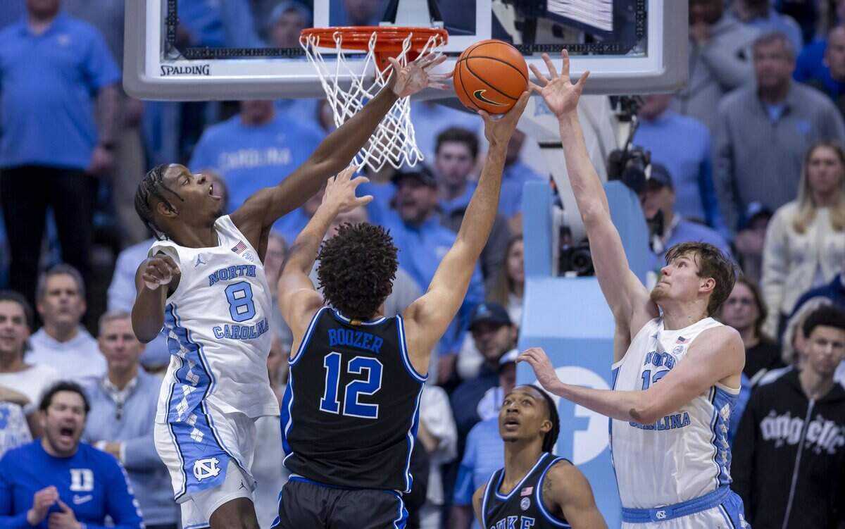 North Carolina forward Caleb Wilson (8) and center Henri Veesaar (13) defend Duke forward Cameron Boozer (12) in the second half on Saturday, February 7, 2026 at the Smith Center in Chapel Hill, N.C.
