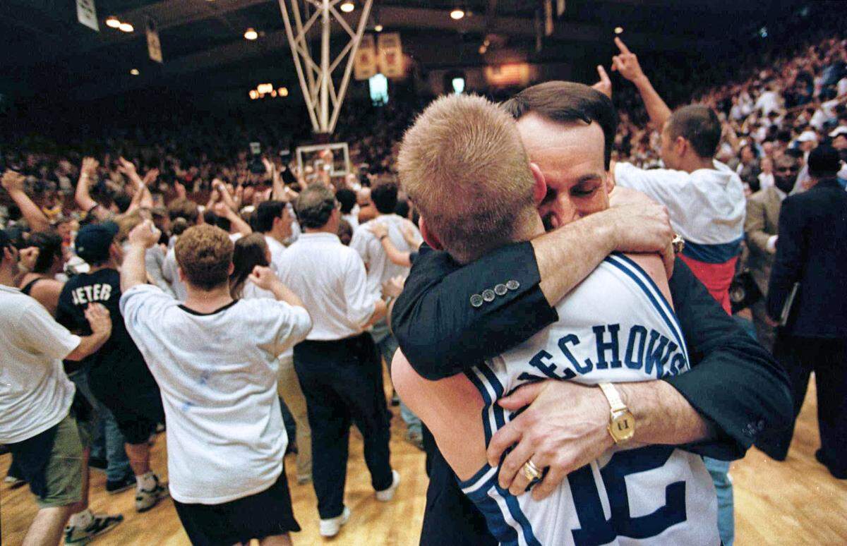 Duke coach Mike Krzyzewski celebrates with senior guard Steve Wojciechowski, who had 11 assists, three steals, and one turnover in the Blue Devils’ 77-75 comeback win against North Carolina in 1998.