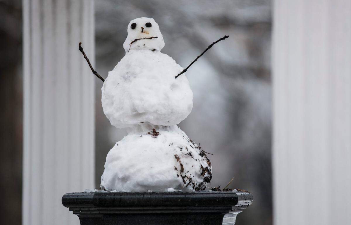 A snow figure sits atop the Old Well water fountain at UNC-Chapel Hill on Thursday morning, January 28, 2021.