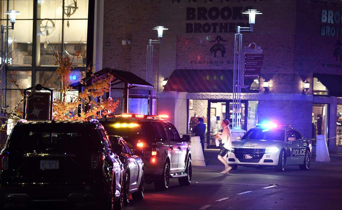 Police vehicles gather at an entrance to the Streets of Southpoint as officers complete the Black Friday evacuation of the mall following an afternoon shooting that left three people wounded, including a 10-year-old.