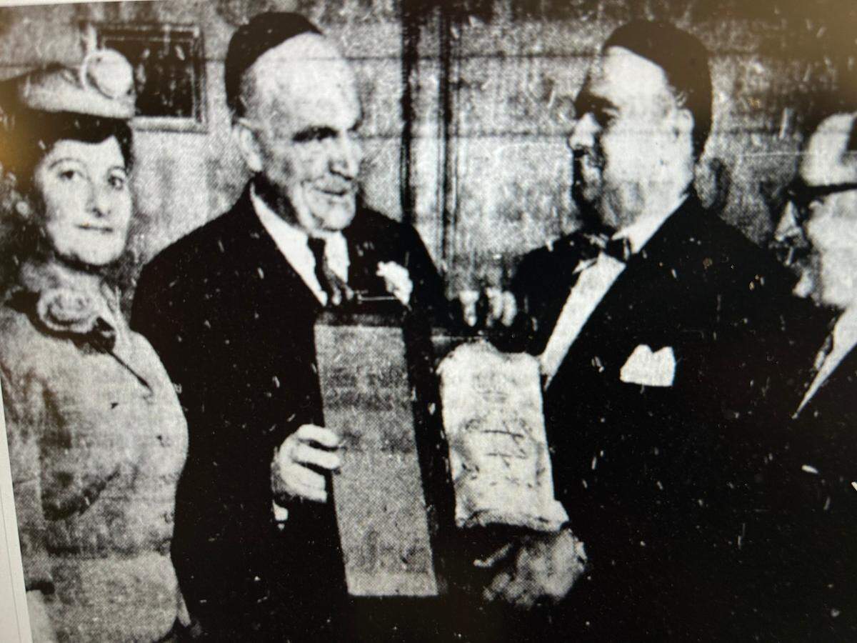 Gov. Luther Hodges receives a Torah as a gift from Beth Meyer Synagogue Rabbi Maurice Idell in 1955.