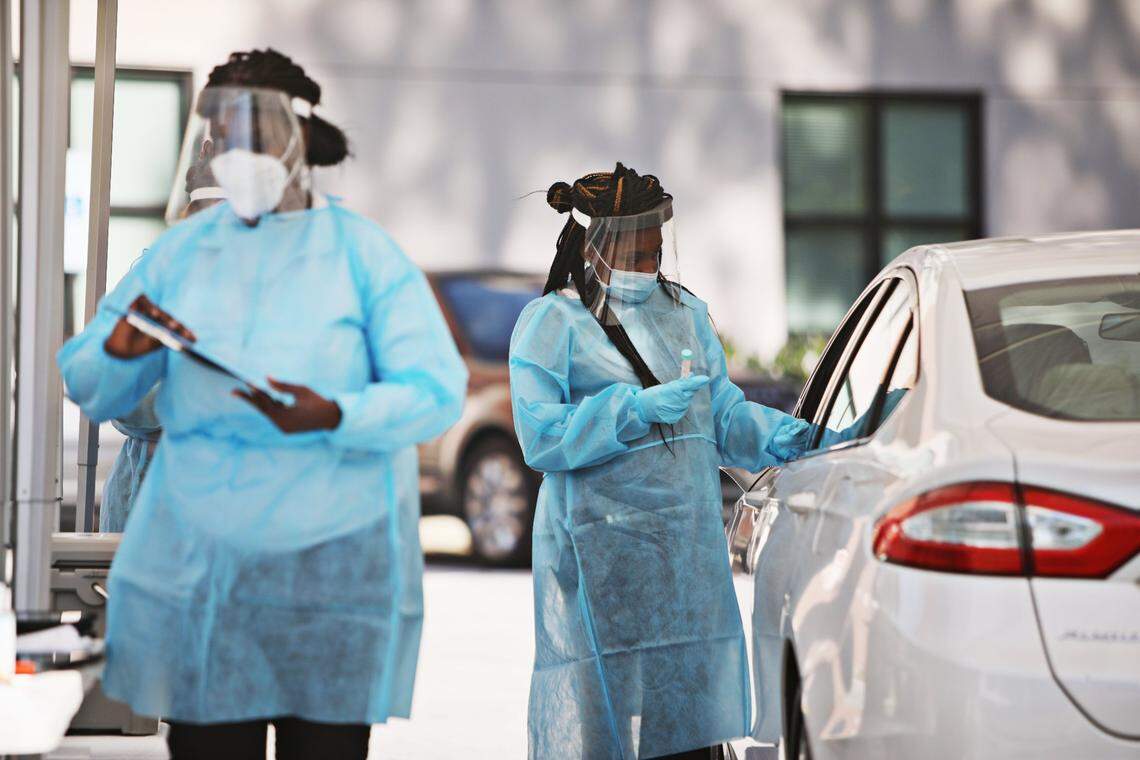 Jaylia Allen, MA, right, collects a sample from a client at a COVID-19 testing drive-thru for Advance Community Health in Raleigh on Thursday, Nov. 5, 2020. Advance Community Health hosts several free testing sites each week.