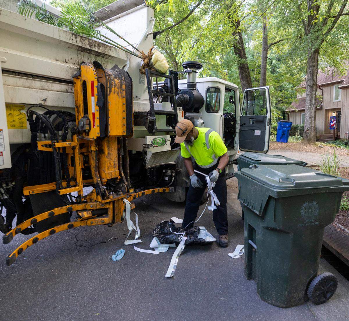 Raleigh Solid Waste Services employee Alonzo Adams separates a discarded house plant that was wrongly placed in a household garbage container during curbside pick-up on Wednesday, July 17, 2024 in Raleigh, N.C. 