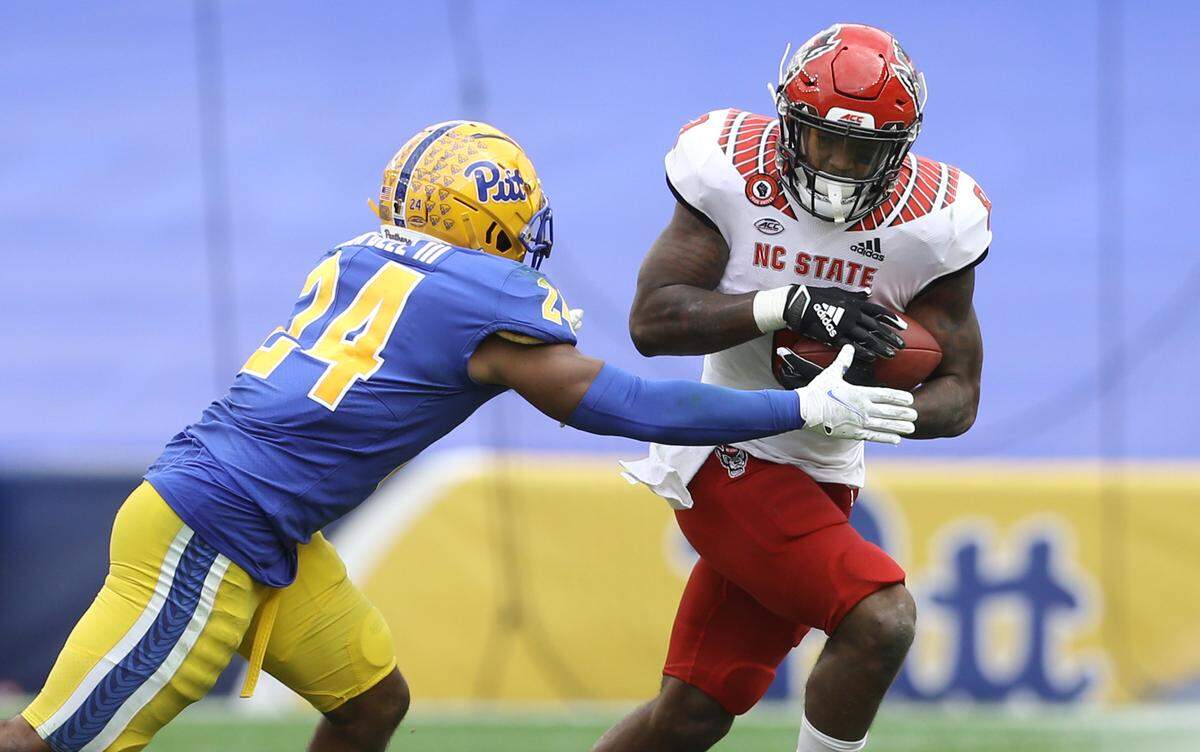 N.C. State’s Ricky Person Jr. (8) runs by Pittsburgh Panthers linebacker Phil Campbell III (24) during the Wolfpack’s game against the Panthers at Heinz Field in Pittsburgh, PA, Saturday, Oct. 3, 2020.