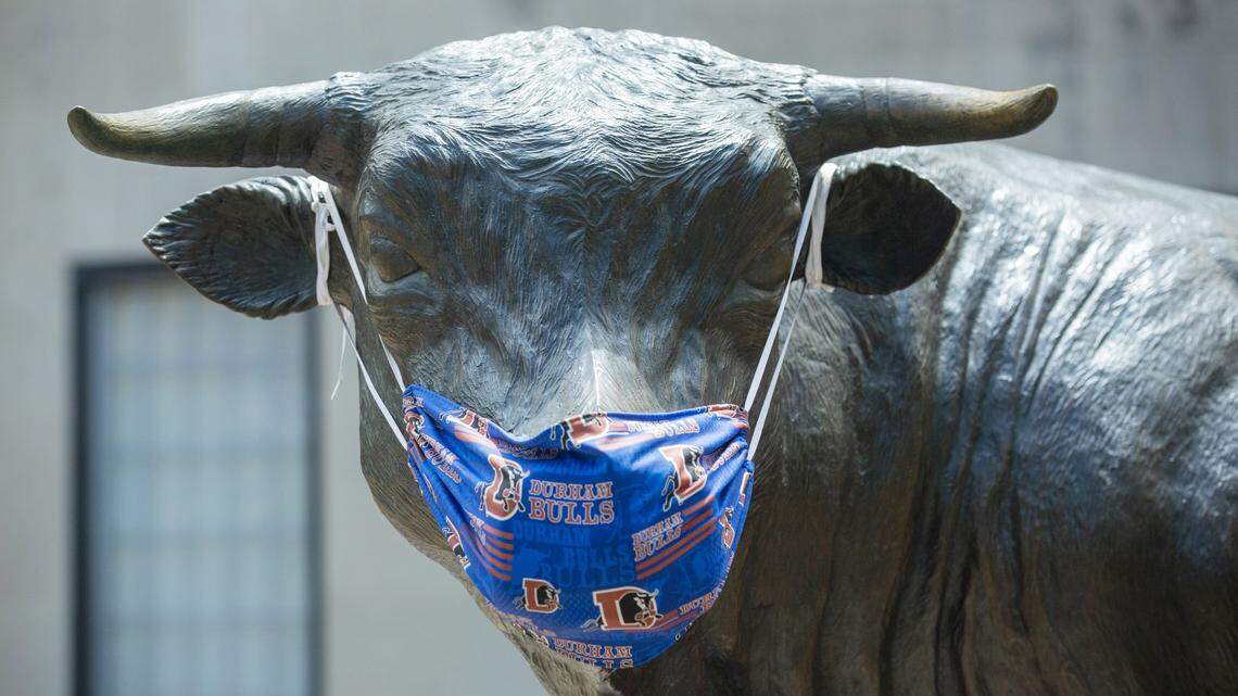 A new mask decorates “Major,” the bronze bull sculpture in CCB Plaza as the joint Durham City and County stay-at-home order is announced to be extended past its Friday expiration date, on Tuesday, May 12, 2020, in Durham, N.C.