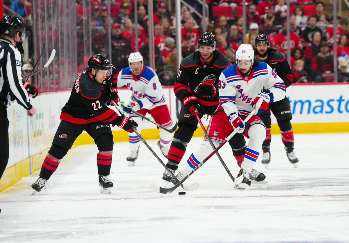 New York Rangers center Mika Zibanejad (93) skates with the puck against Carolina Hurricanes center Logan Stankoven (22) and center Jordan Staal (11) during the first period at Lenovo Center.