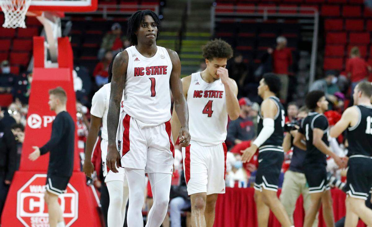 N.C. State’s Dereon Seabron (1) and Jericole Hellems (4) walk off the court after Wright State’s 84-70 victory over N.C. State at PNC Arena in Raleigh, N.C., Tuesday, December 21, 2021.