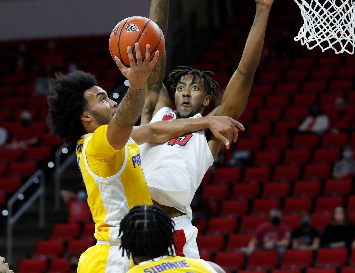Pittsburgh’s Justin Champagnie (11) heads to the basket as N.C. State’s Manny Bates (15) defends during the first half of N.C. State’s game against Pittsburgh at PNC Arena in Raleigh, N.C., Sunday, February 28, 2021.