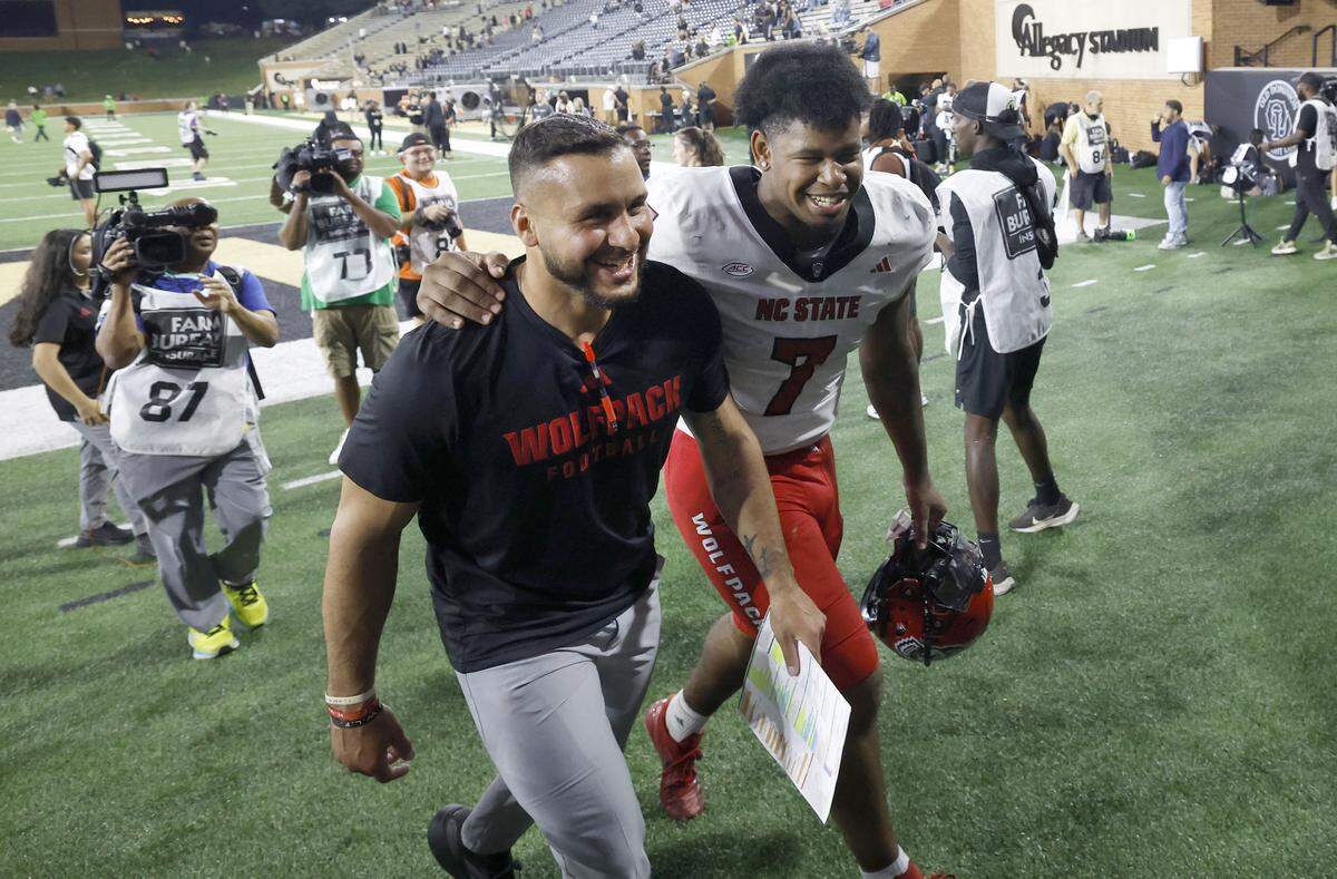N.C. State’s Justin Joly (7) walks off the field with tight ends coach Gavin Locklear after the Wolfpack’s 34-24 victory over Wake Forest at Allegacy Stadium in Winston-Salem, N.C., Thursday, Sept. 11, 2025.