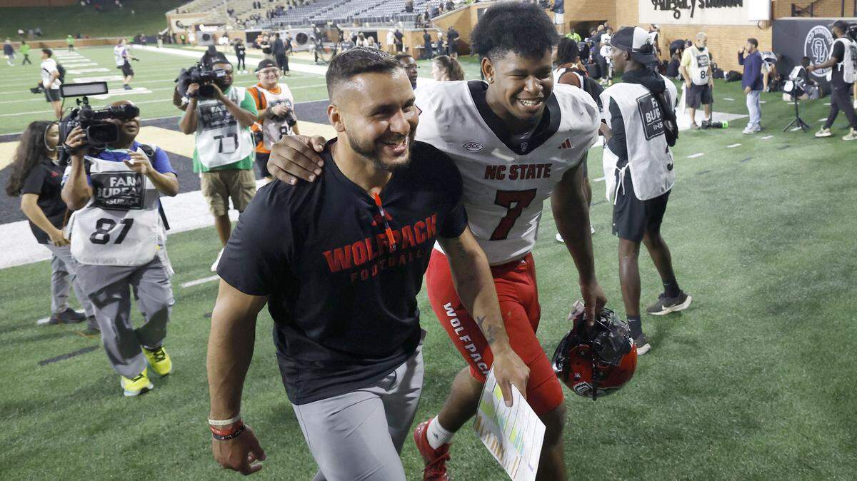 N.C. State’s Justin Joly (7) walks off the field with tight ends coach Gavin Locklear after the Wolfpack’s 34-24 victory over Wake Forest at Allegacy Stadium in Winston-Salem, N.C., Thursday, Sept. 11, 2025.