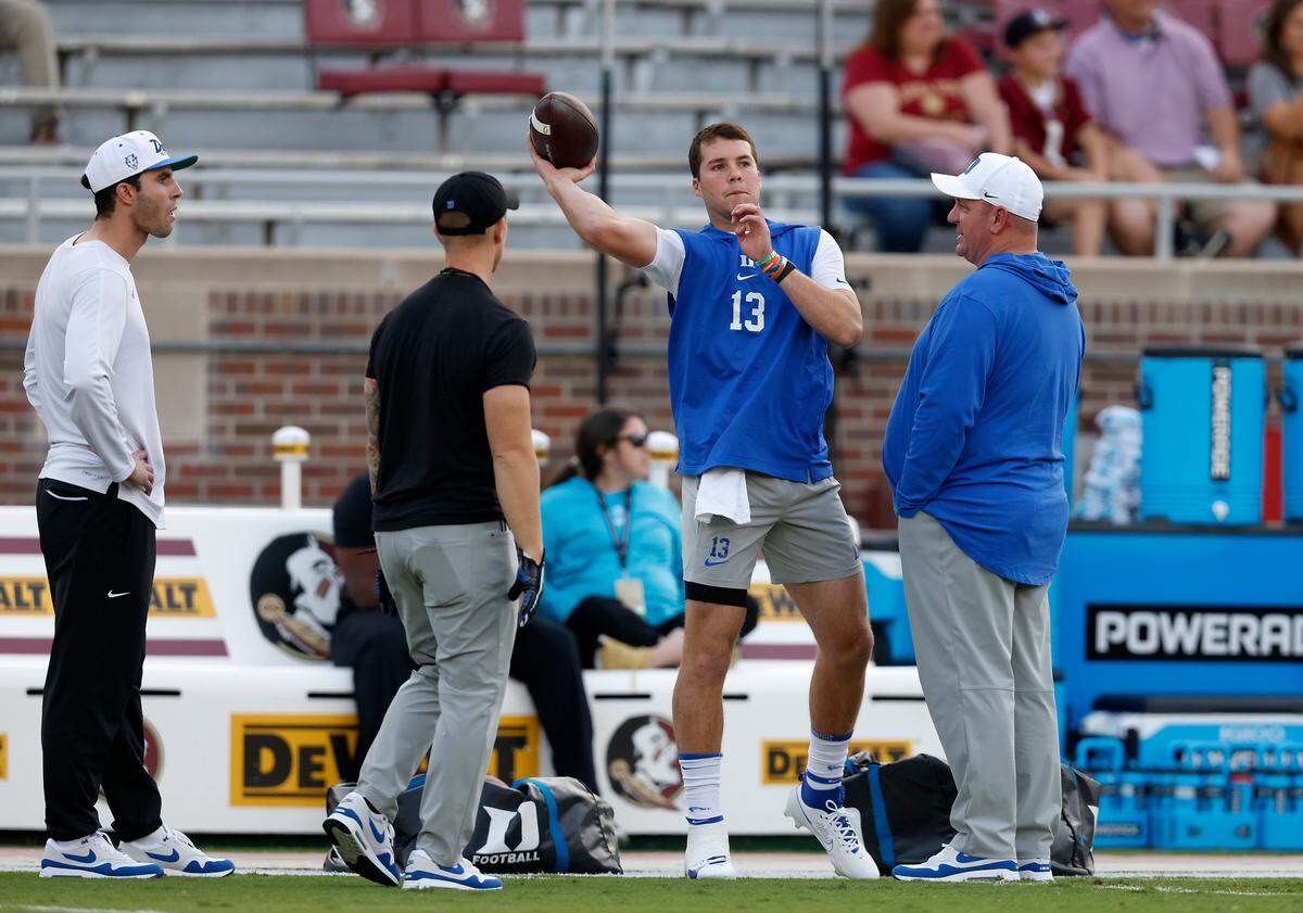 Duke head coach Mike Elko watches as Riley Leonard warms up before the Blue Devils’ game against Florida State on Saturday, Oct. 21, 2023, in Tallahassee, Fla.