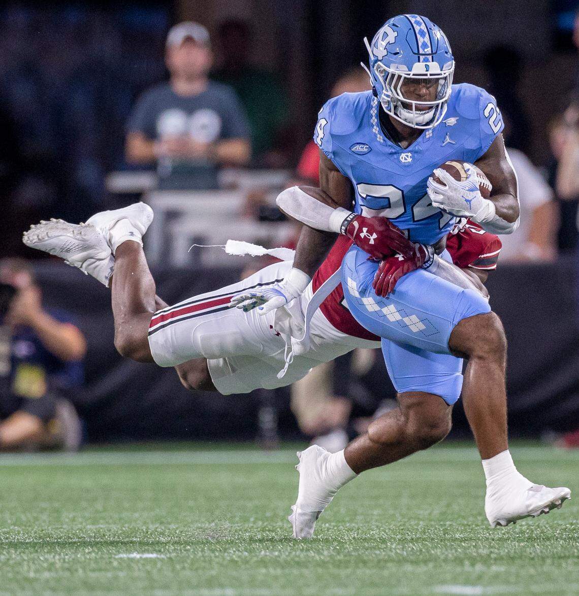 North Carolina running back British Brooks (24) breaks away from South Carolina’s Nick Emmanwori (21) for a 8-yard gain after a pass from quarterback Drake Maye in the first quarter on Saturday September 2, 2023 at Bank of America Stadium in Charlotte, N.C.