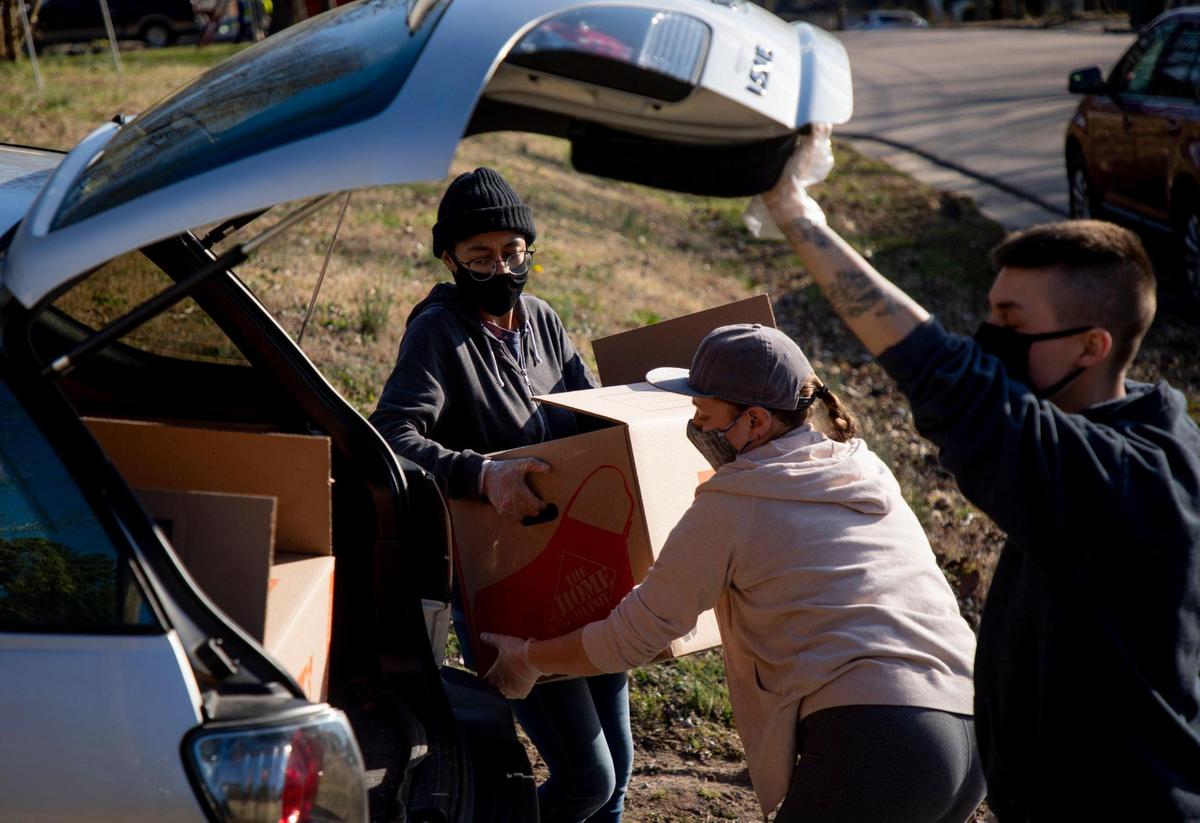 From left, Kirsten Blackburn, Virgina Wertman, and Grayson Harvey, help load a trunk full of food on the final day of the five-day no-contact cookout known as Feed Durham that began as a response to the increase of food insecurity at the start of coronavirus pandemic, bringing dozens of volunteers together every six to eight weeks to cook well-seasoned and nutrient-dense meals for people in need, on Wednesday, Mar. 3, 2021, in Durham, N.C.