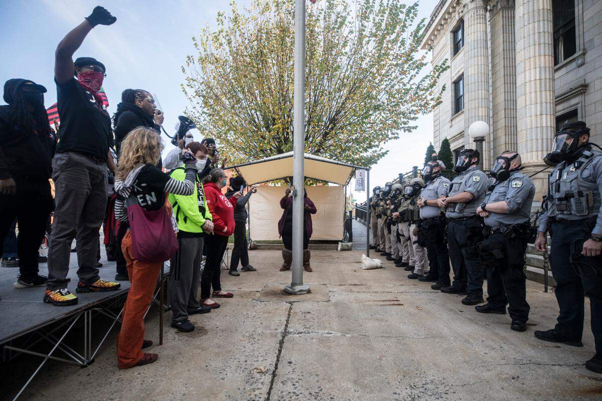 Protesters and Alamance County sheriff’s deputies in riot gear face off in front of the courthouse in Graham, N.C. on Saturday, Oct. 31, 2020 before pepper spray was used and several people were arrested.