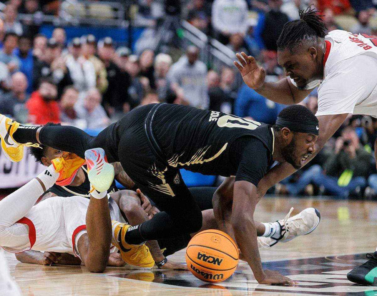 Oakland’s DQ Cole and N.C. State’s DJ Burns Jr. scramble for a loose ball during the second half of the Wolfpack’s 79-73 overtime win in the second round of the NCAA Tournament on Saturday, March 23, 2024, at PPG Paints Arena in Pittsburgh, Pa.