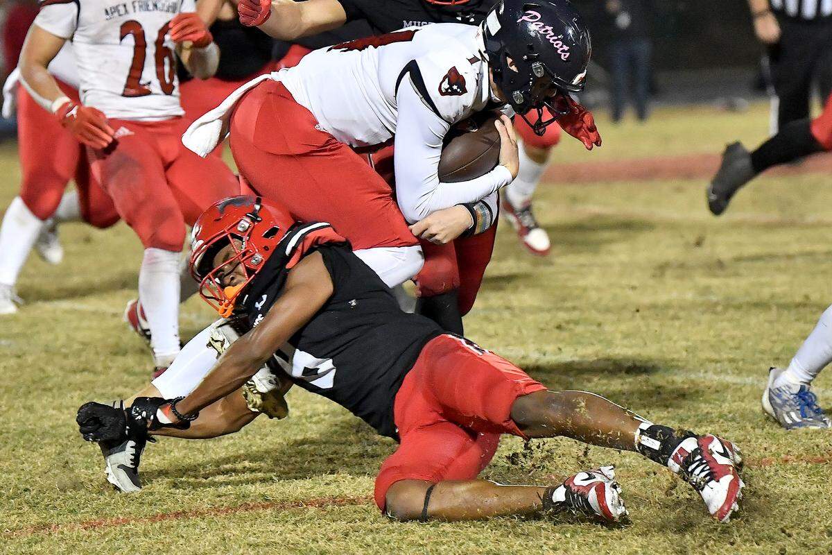 Middle Creek’s Malachi Biggs (8) trips up Apex Friendship quarterback Dominick Parrinello (14) during the second half. The Middle Creek Mustangs and the Apex Friendship Patriots met in a football game in Cary, N.C. on October 25, 2024.