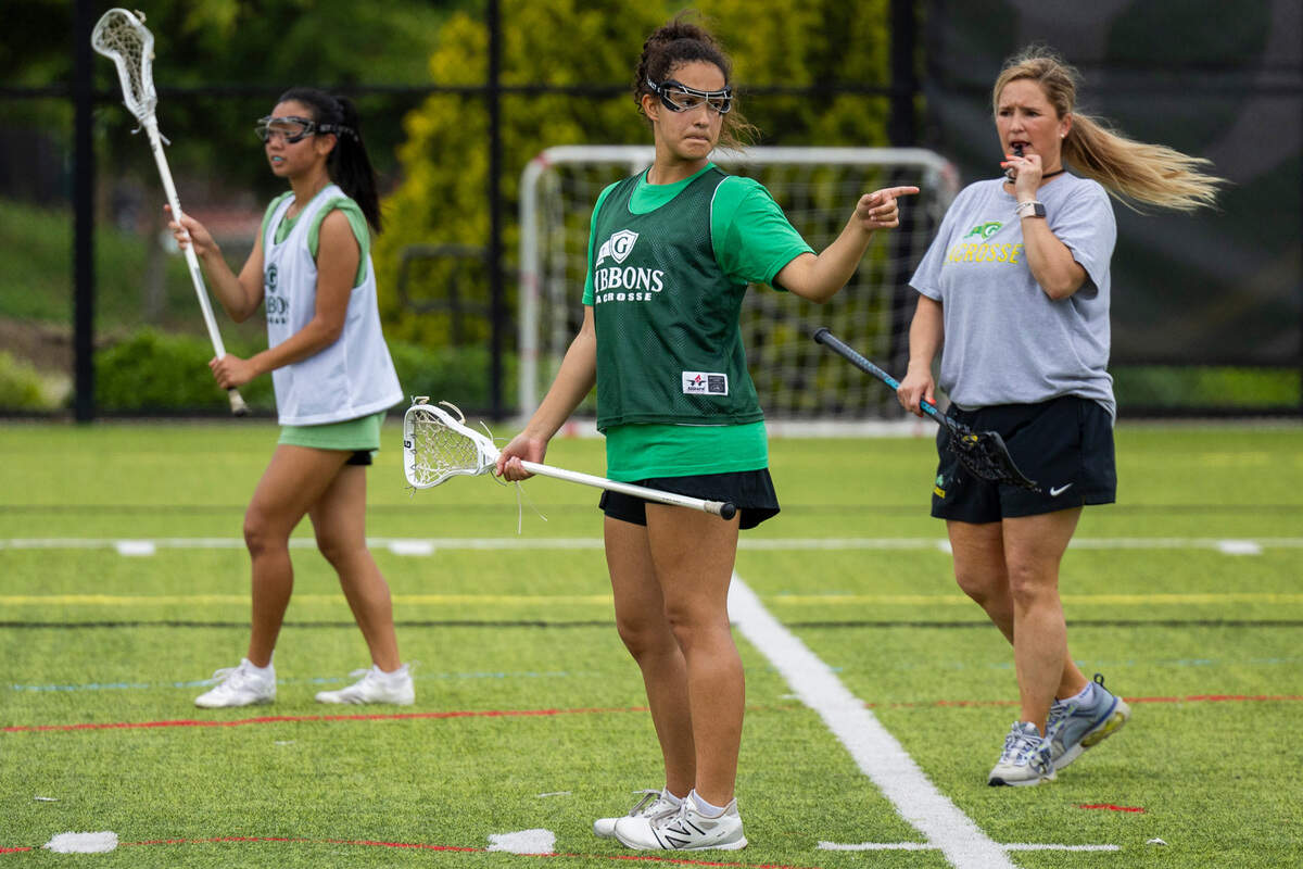 Coach Patricia Alexander, right, leads her girls’ lacrosse team, that includes her daughter Taylor Alexander, center, during a practice at Cardinal Gibbons High School on Wednesday, May 8, 2024.