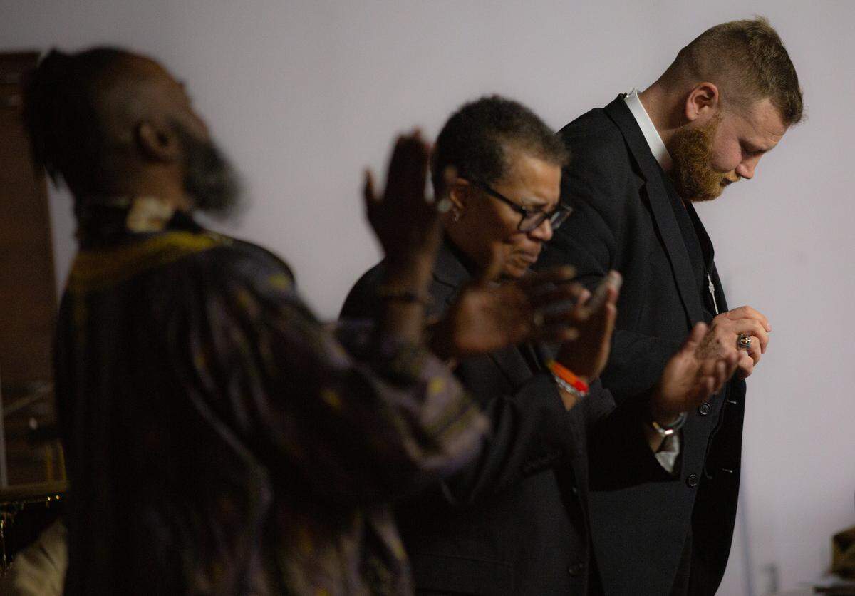 Pastor Vance Haywood (right) bows his head during a service on March 1, 2020 St. John’s Metropolitan Community Church in Raleigh.
