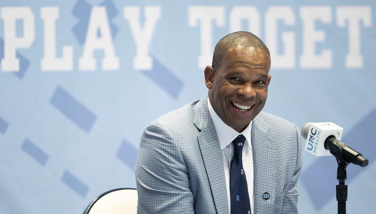 Hubert Davis flashes a smile as he fields questions from reporters after he was introduced at the new head basketball coach a the University of North Carolina on Tuesday, April 6, 2021 at the Smith Center in Chapel Hill, N.C. Davis a former North Carolina player and an assistant coach for Roy Williams, replaces Williams who retired last week following 18 years as head coach.