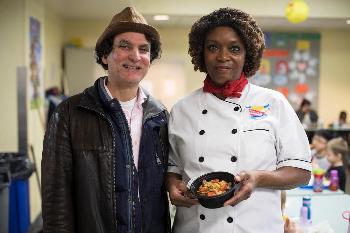 Chef Roberto Copa, owner of downtown Durham restaurant Copa, poses for a portrait with school food service manager Gwendolyn Coley, at George Watts Elementary School on Thursday, Jan 24, 2019. Coley is holding the dish she and Copa created for Durham Public Schools, the Cuban pork and rice bowl.