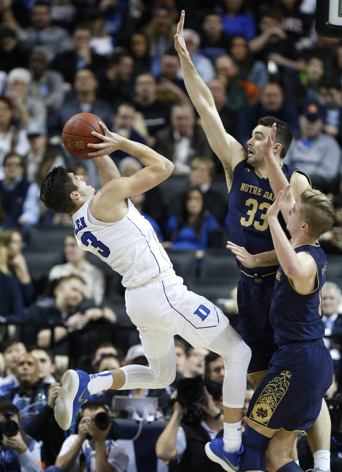 Duke's Grayson Allen (3) shoots as Notre Dame's John Mooney (33) and Rex Pflueger (0) defend during the second half of Duke's 88-70 victory over Notre Dame in the quarterfinals of the 2018 New York Life ACC Tournament at the Barclays Center in Brooklyn, NY, Thursday, March 8, 2018.
