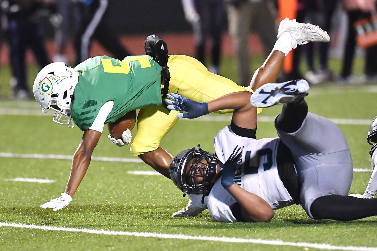 Cardinal Gibbons’ Kendall Scotton (5) goes for the extra yardage against Hillside’s Sterling Edwards (5) during the first half. The Cardinal Gibbons Crusaders and the Durham Hillside Hornets met in the third round of the NCHSAA 4A playoffs in Raleigh, N.C. on November 29, 2024.