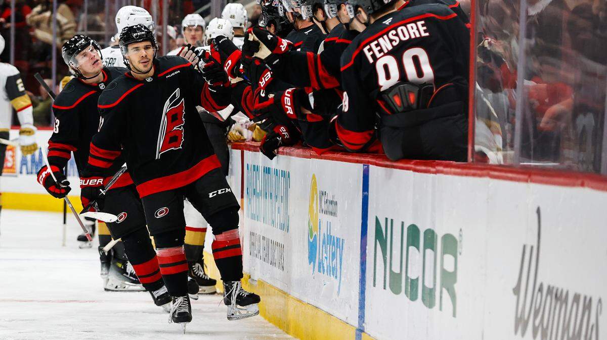 Logan Stankoven of the Carolina Hurricanes celebrates with teammates on the bench after scoring goal during the third period of the game against the Vegas Golden Knights at the Lenovo Center on Oct. 28, 2025 in Raleigh, North Carolina.