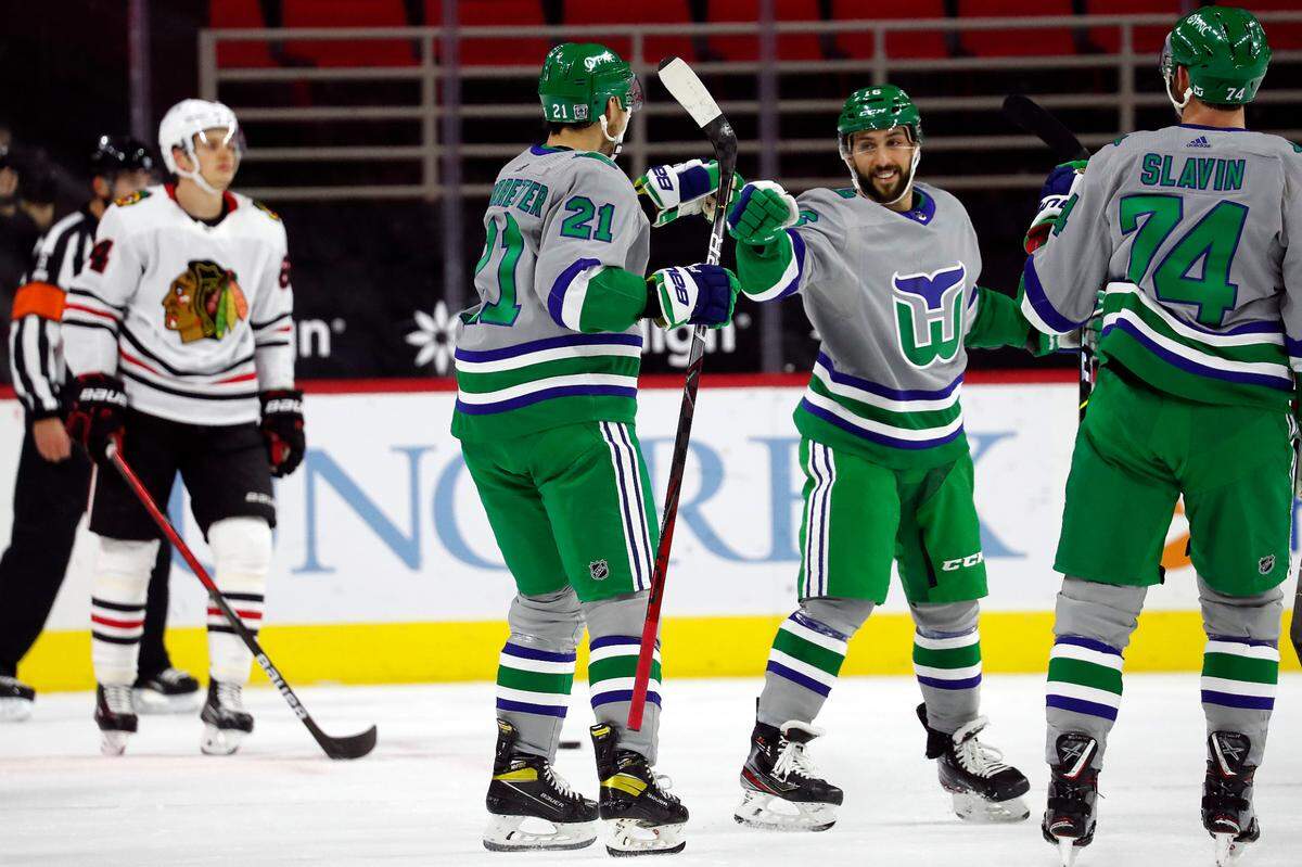 Carolina Hurricanes’ Nino Niederreiter (21) is congratulated on his goal by teammate Vincent Trocheck (16), center, and Jaccob Slavin (74) during the first period of an NHL hockey game against the Chicago Blackhawks in Raleigh, N.C., Friday, Feb. 19, 2021. (AP Photo/Karl B DeBlaker)
