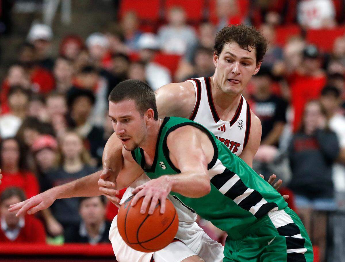 N.C. State’s Ben Middlebrooks pressures USC Upstate’s Nic Book during the first half of the Wolfpack’s 97-66 win on Monday, Nov. 4, 2024, at Lenovo Center in Raleigh, N.C.