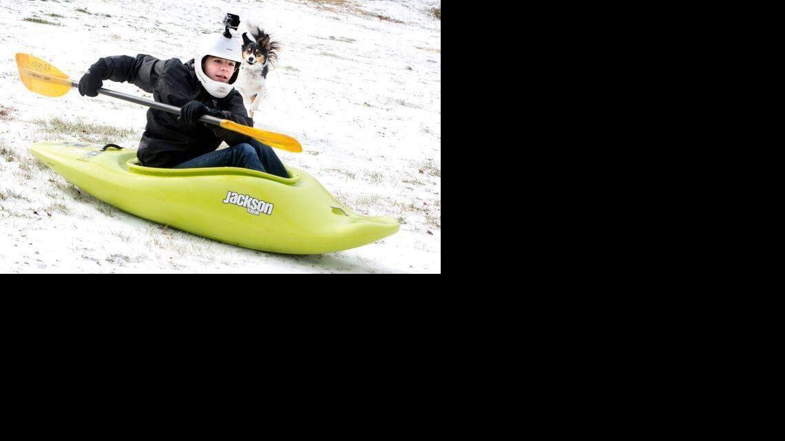 Branson Gray, 15, of Raleigh, uses his kayak for sledding on the Dorothea Dix campus with his dog April at his side on Tuesday, February 17, 2015.
