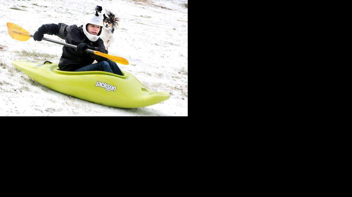 Branson Gray, 15, of Raleigh, uses his kayak for sledding on the Dorothea Dix campus with his dog April at his side on Tuesday, February 17, 2015.
