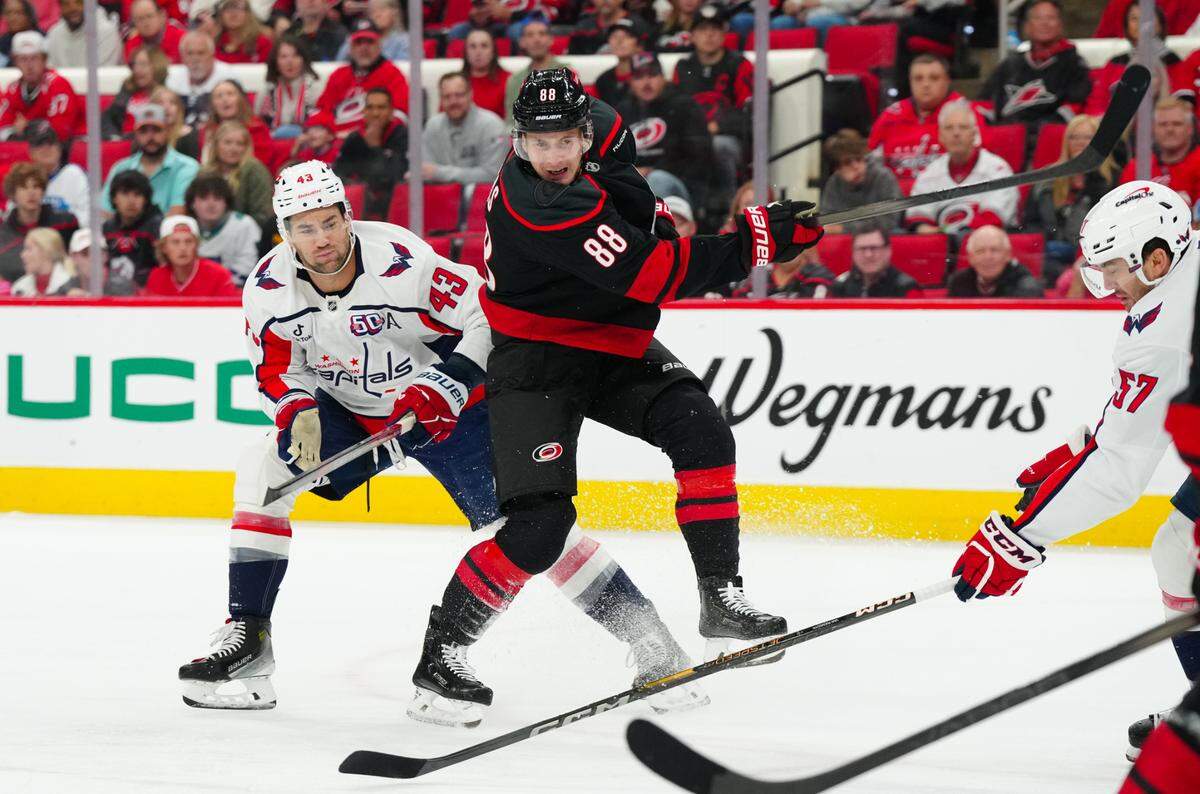 Carolina Hurricanes center Martin Necas (88) gets the shot away against Washington Capitals right wing Tom Wilson (43) during the first period at Lenovo Center.