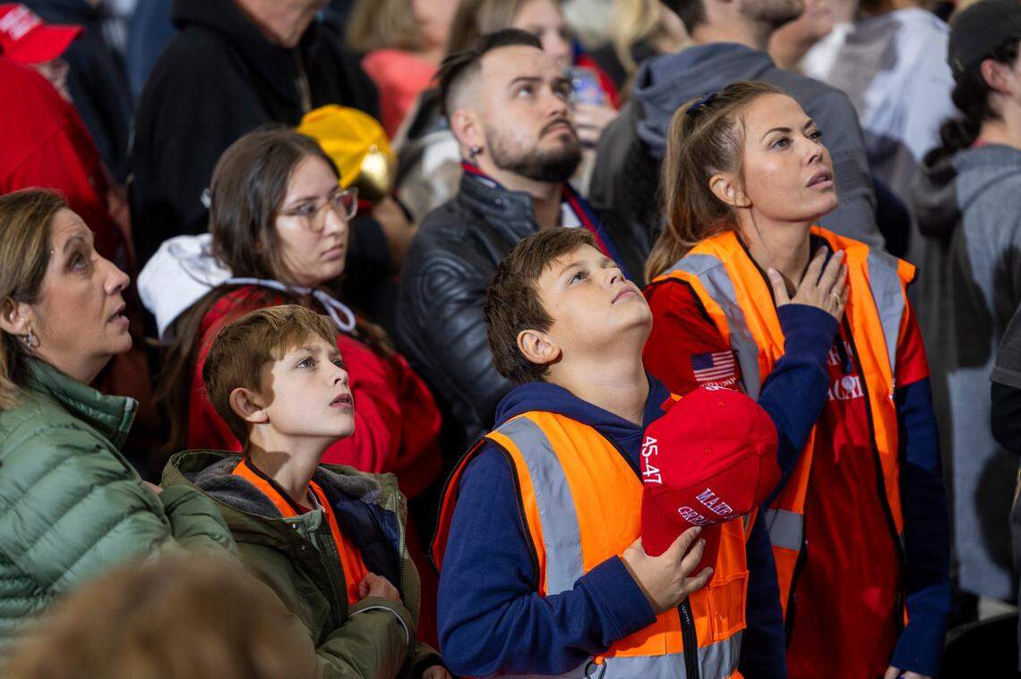 Supporters of Republican presidential nominee and former President Donald Trump stand during the National Anthem during a campaign rally at Dorton Arena in Raleigh on Monday, Nov. 4, 2024, one day before Election Day.