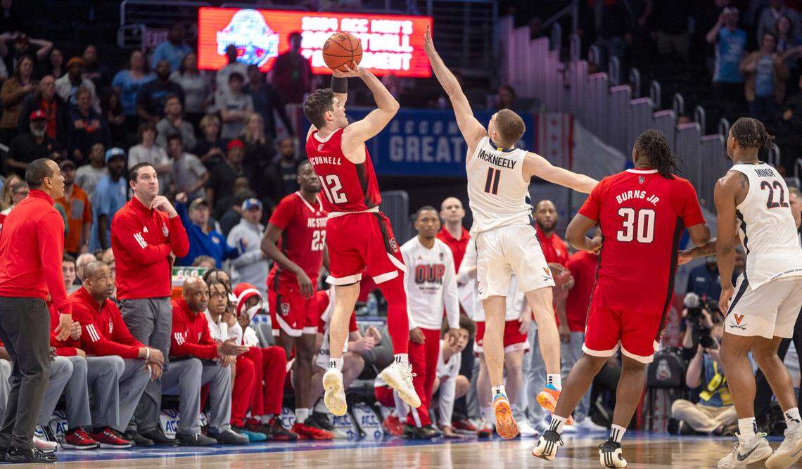 N.C. State’s Michael O’Connell (12) launches a three-point shot over Virginia’s Isaac McKneely (11) at the buzzer in regulation to tie Virginia 58-58 and force overtime during the semi-finals of the ACC Men’s Basketball Tournament at Capitol One Arena on Friday, March 15, 2024 in Washington, D.C.
