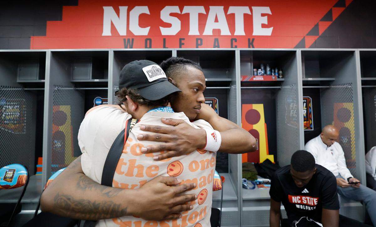 N.C. State’s DJ Horne (0) hugs Wolfpack student and 247 photographer Spencer Thomas in the locker room after Purdue’s 63-50 victory over N.C. State in the NCAA Tournament national semifinals at State Farm Stadium in Glendale, Ariz., Saturday, April 6, 2024.