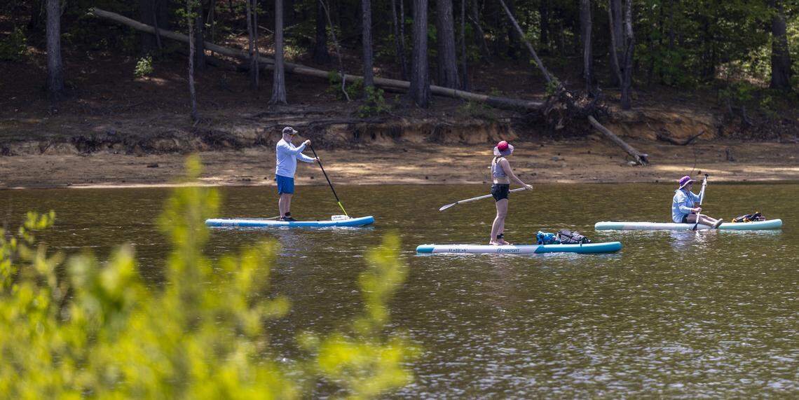 Paddleboarders set out across Falls Lake from the Beaver Dam Primitive Access Area on Thursday, April 16, 2026, as central North Carolina faces drought conditions and water restrictions. The lake’s water level was about 249 feet on April 15, according to the U.S. Geological Survey, following little recent rainfall.