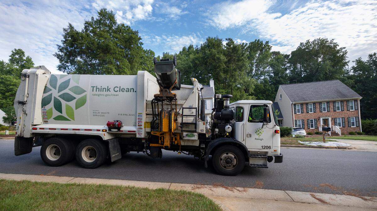 Raleigh Solid Waste Services employee Alonzo Adams collects household garbage from one of about 1200 residences during his shift on Wednesday, July 17, 2024 in Raleigh, N.C. Adams, works alone using an automated side loader to empty curbside receptacles.