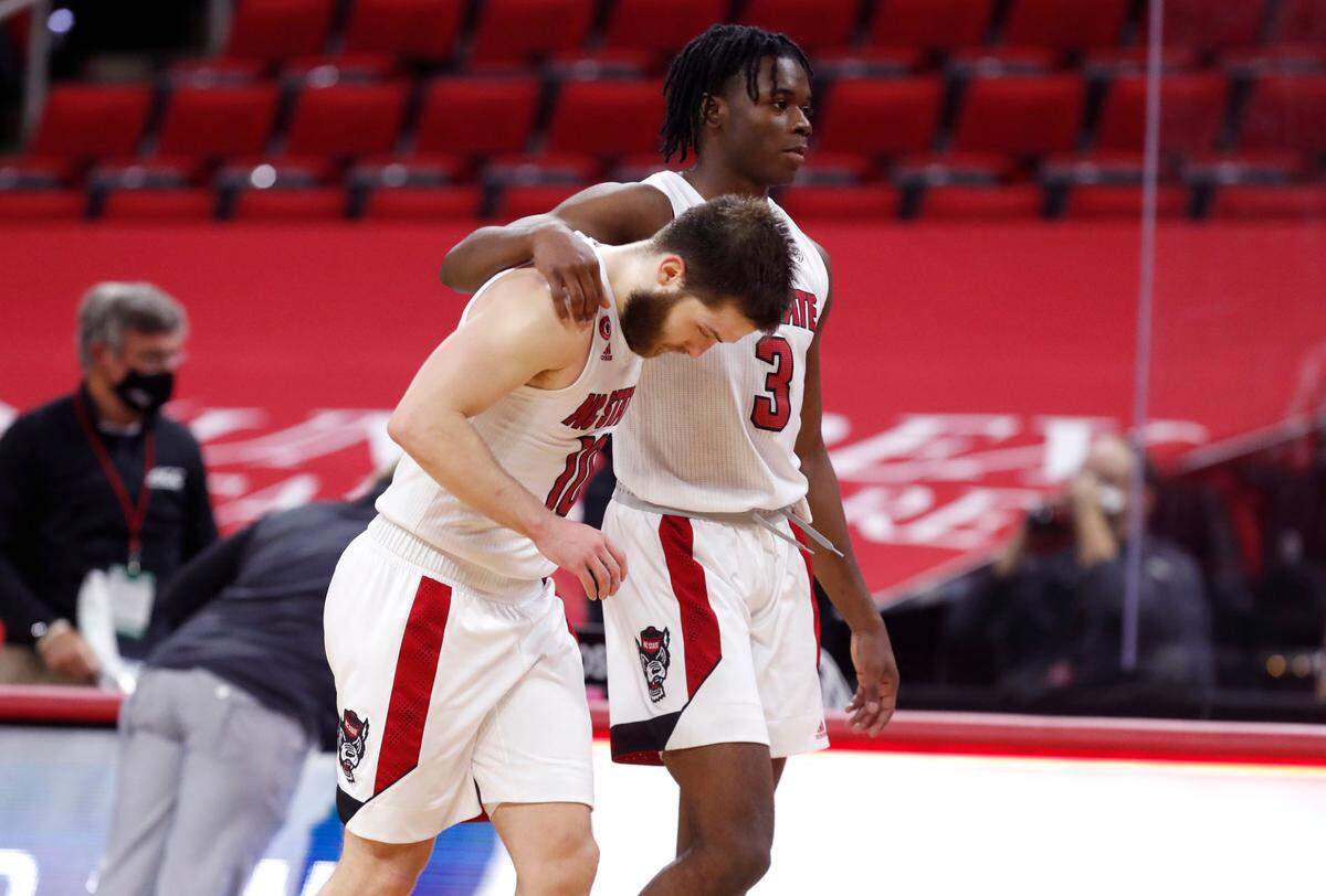 N.C. State’s Cam Hayes (3) walks off the court with Braxton Beverly (10) after Virginia’s 64-57 victory over N.C. State at PNC Arena in Raleigh, N.C., Wednesday, February 3, 2021.