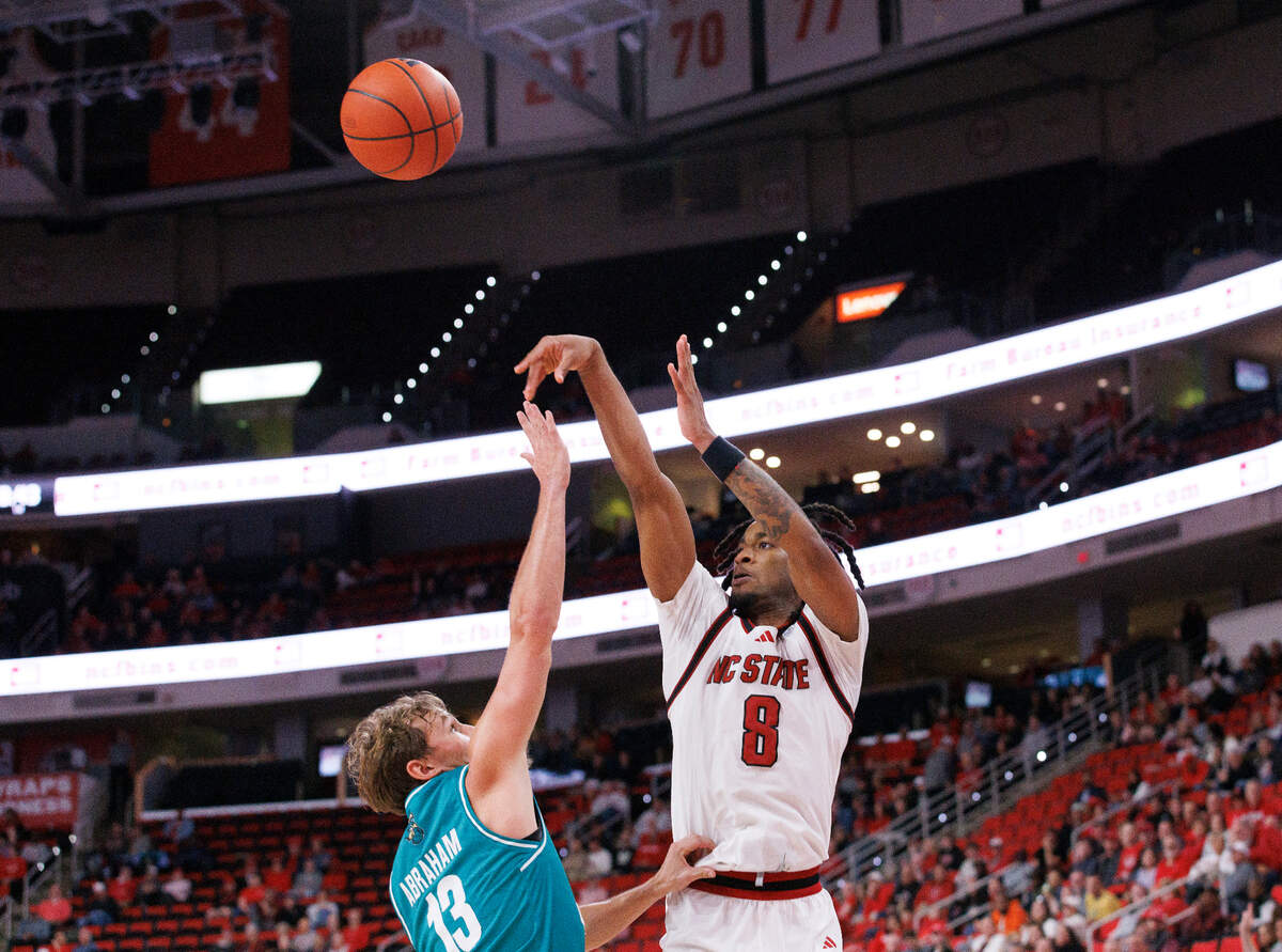 N.C. State’s Jayden Taylor shoots over Coastal Carolina’s Henry Abraham during the second half of the Wolfpack’s 82-70 win on Wednesday, Nov. 13, 2024, at Lenovo Center in Raleigh, N.C.