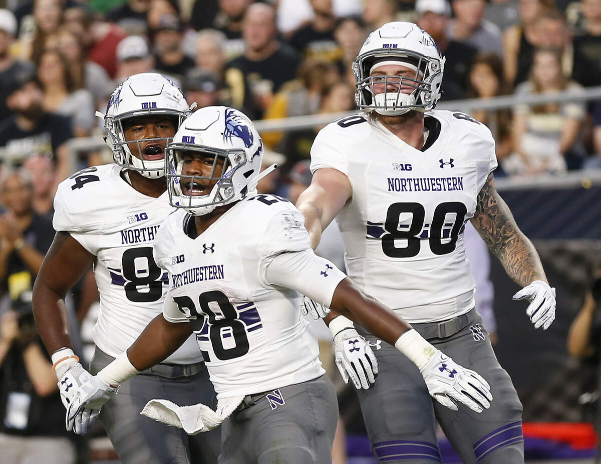 Northwestern’s Jeremy Larkin, center, celebrates with Cameron Green, left, and Trey Pugh, right, after his rushing touchdown against Purdue on Aug. 30.