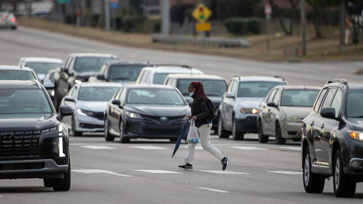 A pedestrian crosses the nine lanes of South Wilmington Street at Chapanoke Road in Raleigh in January 2023.